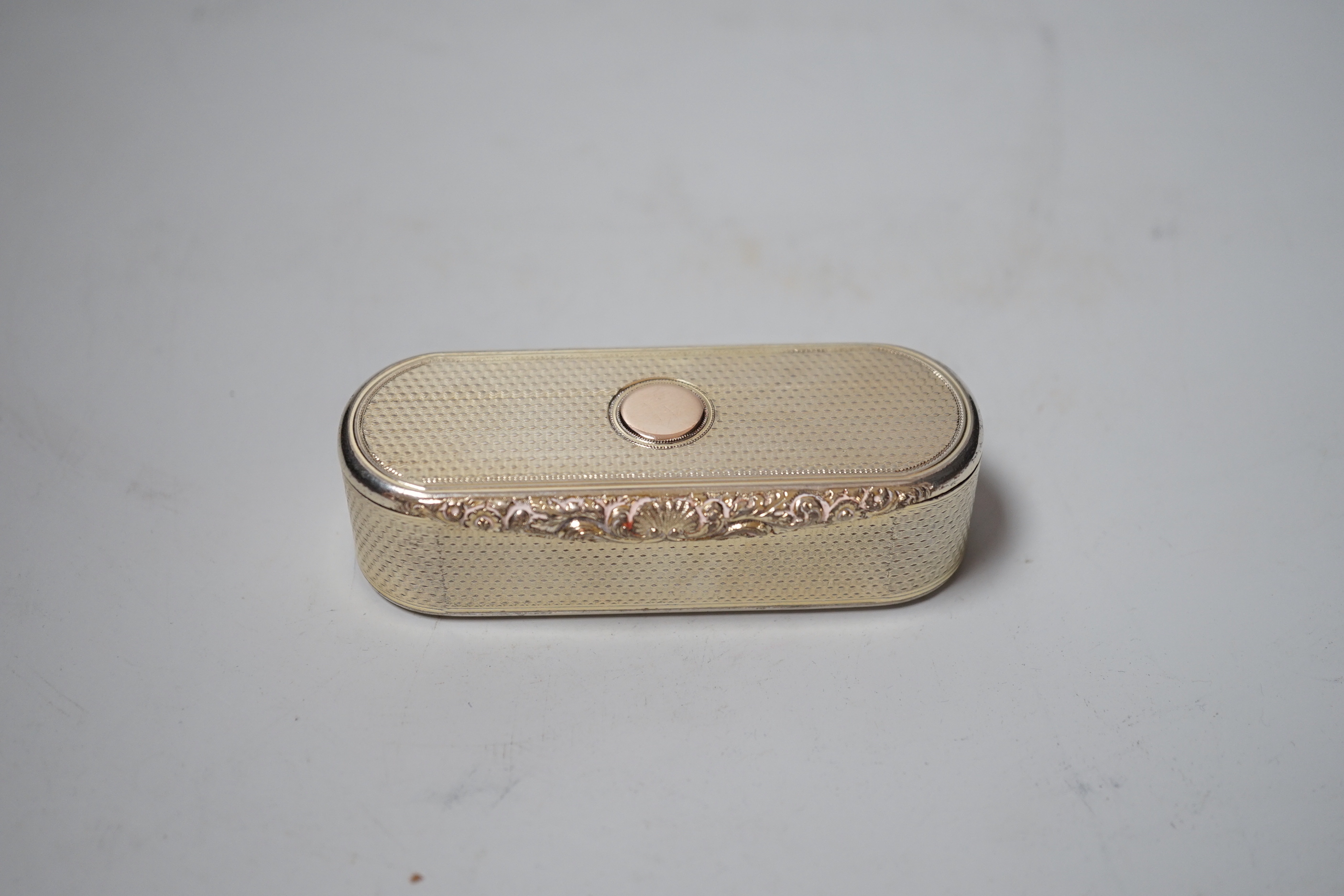 A George IV engine turned silver gilt oval snuff box, with interior Latin inscription, John Linnit, London, 1828, 9cm.